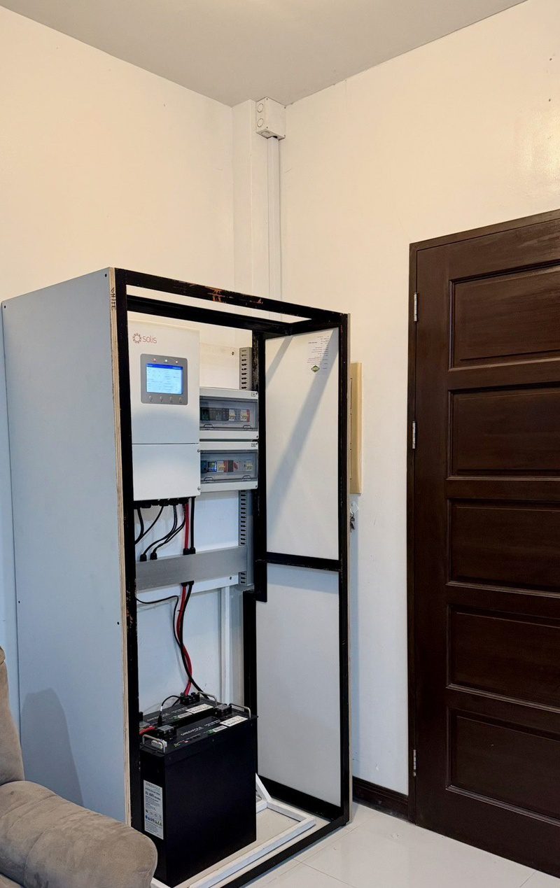 The cabinet with its frame open: inverter and protection boxes on top, battery at the base.